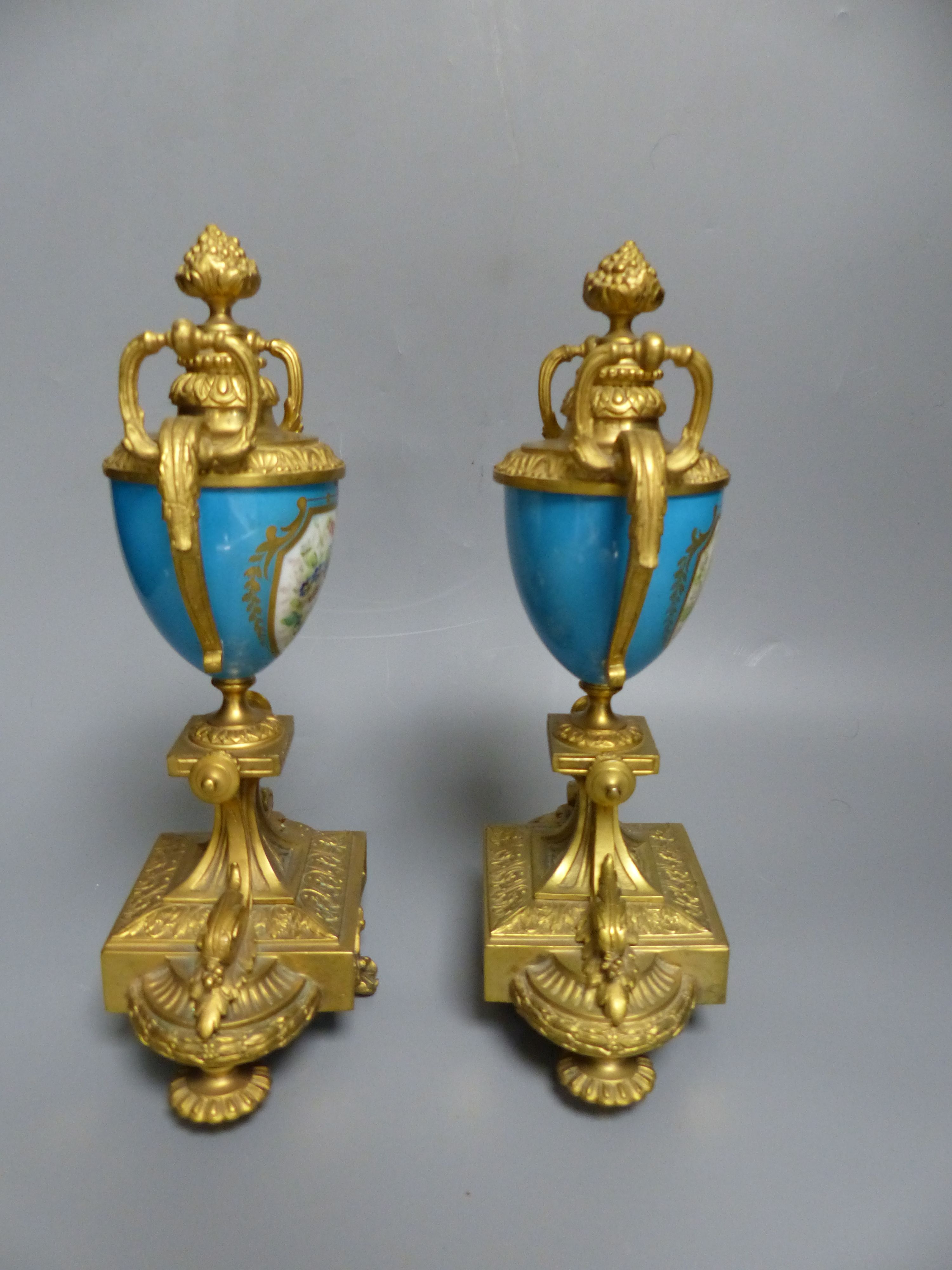 A pair of 19th century French ormolu and Sevres style porcelain urns, decorated with flowers and landscapes, height 26.5cm